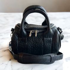 * Some Wear On Edges And Top Handle, Good Condition! * Two Inner Pockets, One Zip, One Flat Open * Base Length: 8.25 In * Height: 5.25 In * Width: 5.5 In * Silver-Tone Hardware * Crossbody Style Black Pebbled Leather Shoulder Bag With Silver-tone Hardware, Crossbody Bags In Pebbled Leather With Palladium Hardware, Luxury Bag With Gunmetal Hardware And Pebbled Leather, Black Pebbled Leather Bag With Gunmetal Hardware, Black Pebbled Leather Shoulder Bag With Soft Leather, Luxury Top Handle Bag With Pebbled Texture, Leather Shoulder Bag With Pebbled Texture And Top Handle, Leather Top Handle Shoulder Bag With Pebbled Texture, Black Pebbled Leather Bag With Palladium Hardware