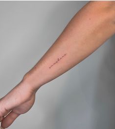 a person's arm with a small tattoo on it