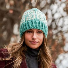 a woman wearing a green and white knitted hat