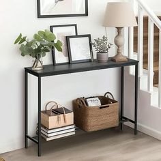 there is a shelf with pictures on it next to a stair case and baskets under the banister