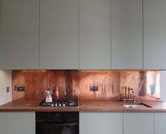 a kitchen with stainless steel appliances and wooden counter tops, along with white cupboards