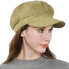 a woman wearing a green hat and grey sweater