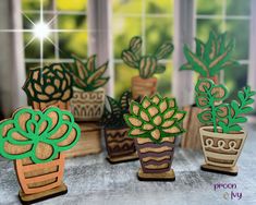 three small wooden planters sitting next to each other on top of a table in front of a window