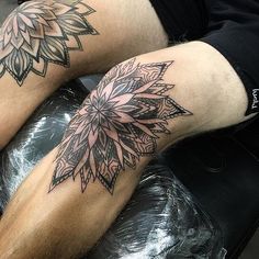 a man sitting on top of a black chair next to his legs with tattoos on them