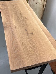 a wooden table with metal legs in a workshop area next to other woodworking tools