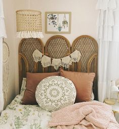 a bedroom with wicker headboard and pillows on top of the bedspread