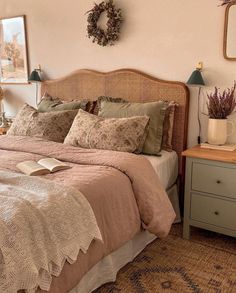 a bedroom with a bed, nightstands and two mirrors on the wall above it