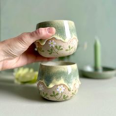 two green and white bowls sitting on top of a table next to eachother