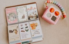 a pink radio sitting on top of a table next to a box filled with books