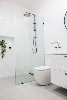 a bathroom with a toilet, sink and shower stall in it's own area