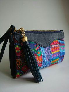 a multicolored purse with tassels on the front and side, sitting on a white surface