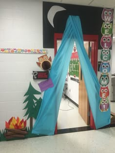 an owl themed classroom door decorated with blue drapes and owls on the front wall