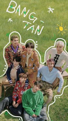 a group of young men sitting next to each other on top of a lush green field