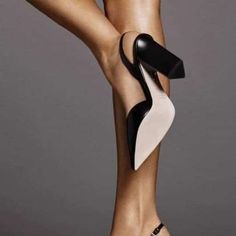 a woman's legs with high heels and black and white shoes on top of them