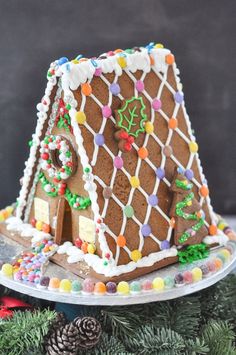 a decorated gingerbread house on a platter