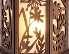 an intricately carved wooden lantern with flowers and leaves on the front, lit by a light bulb