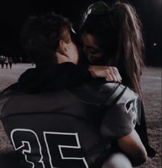 a man and woman hug each other on the field