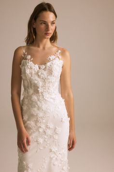 a woman in a white wedding dress with flowers on it