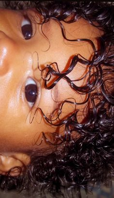 a close up of a child's head with curly hair on top of it