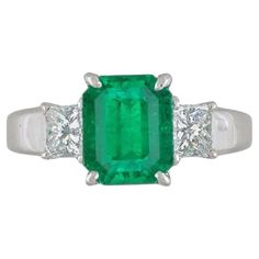 GIA Certified 2.09 carat Emerald Ring with Side Diamonds in Platinum Emerald and Diamond Ring features a bright lively Green Rectangular-cut Emerald in the center with 2 Princess-cut Diamonds set in Platinum. The emerald is of Colombian origin and has undergone F2 Clarity Enhancement. Emerald weight is 2.09 carats and is GIA certified (please see copy of certificate in the photo gallery). Total diamond weight is .65 carats. Ring size is 6.25 Ring weighs 6.0 grams. Set in Platinum. Marked Pt900, Emerald And Diamond Ring, Platinum Diamond Rings, Emerald Diamond Ring, Emerald Engagement, Emerald Engagement Ring, Van Cleef Arpels, Three Stone Rings, Van Cleef, Emerald Diamond