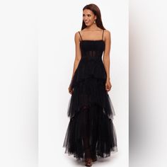 a woman is wearing a black dress with sheer tulle on the bottom and side