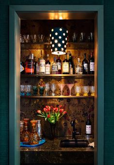 an open cabinet filled with bottles and glasses