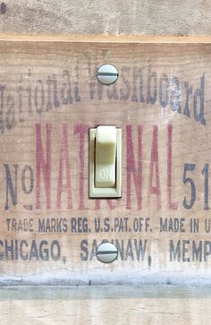 a light switch on the side of a wooden wall with an old sign that says national 51