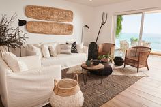 a living room filled with lots of furniture next to an ocean side wall mounted art piece