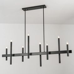 a black chandelier with six candles hanging from it