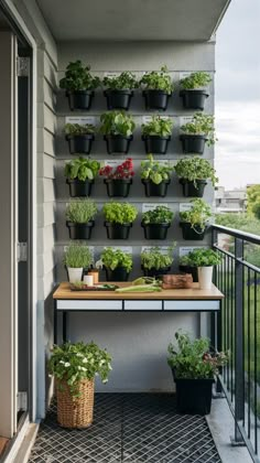 an outdoor balcony with potted plants on the wall and a wooden table in front of it