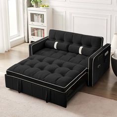 a black futon bed sitting on top of a white rug in a living room