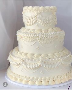 a three tiered wedding cake with white frosting