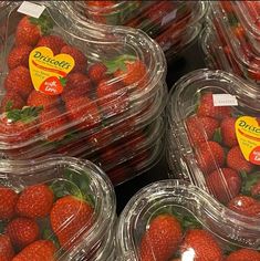 several plastic containers filled with strawberries on display