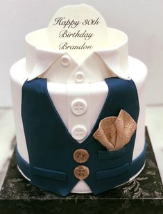 a blue and white birthday cake with buttons on it's lapel collars