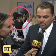 a man in a suit and tie talking to an interviewer with a red circle over his head