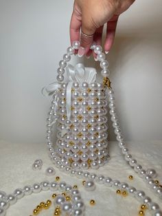 Elevate your outfit with White Pearl Bucket Bag. Perfect as a wedding bag or any other occasions. You can use as handbag or crossbody bag. Removable liner bag and removable pearl strap. Made to order. DM us to order 2 or more pieces. Measurements: Height - 5 inches Diameter - 3 inches Pearl strap  - 47 inches Materials: Acrylic pearl beads 14mm , pearl strap 12mm, gold beads 6mm Satin clothe Elegant Bucket Bag With Pearl Handle, Pearl Bucket Bag, Luxury Bucket Bag With Pearl Handle, Wedding Pearl Beaded Bags, Elegant Beaded Bucket Bag, Satin Clothing, Pearl Bag, Wedding Bag, Beaded Bags