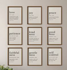 six framed quotes on the wall above a table with a potted plant in it