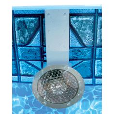 an overhead view of a swimming pool with clear water and blue glass blocks in the background