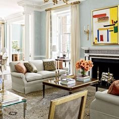 a living room filled with furniture and a fire place in the middle of a room