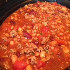 a pot filled with beans and meat in tomato sauce