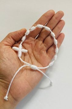 a hand holding a white string with an anchor on it