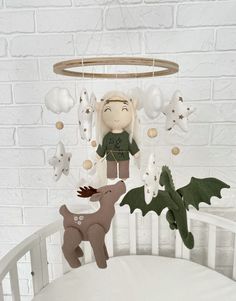 a baby crib with a stuffed animal and decorations hanging from it's sides