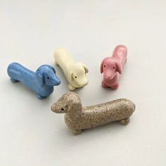 four small toy dogs sitting next to each other on a white surface with one dog in the middle