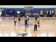 some kids are playing basketball on a court with an instructor in the backround