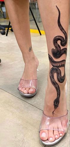 a woman's foot with a snake tattoo on it