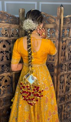 a woman in a yellow dress is standing near a wooden door