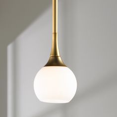 a light fixture hanging from the ceiling in a room with white walls and flooring