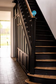 a blue frisbee sitting on top of a wooden banister next to a stair case