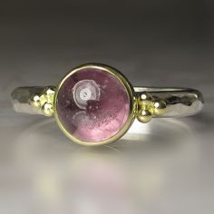 Beautiful, natural spinel cabochon set in 18k bezel on hammered sterling silver band(approx. 2.5mm wide x 1.5mm thick). The spinel has a backsheet of polished fine silver(closed setting). Classic 18k gold granule clusters on each side of the spinel. The spinel measures approx. 7mm in diameter X 5mm deep and weighs 2.63cts.  All metal is from recycled sources. This ring is a size 6 3/4 and I cannot resize. Attractively boxed. Photos have been taken up close for detail. Please refer to dimensions. Gold Jewelry With Round Black Spinel, Minimalist Silver Black Spinel Jewelry, Fine Jewelry In Silver With Black Spinel, Black Spinel Cocktail Ring, Silver Black Spinel Ring, Spinel Ring, Bezel Set Ring, Hammered Sterling Silver, Cabochon Ring