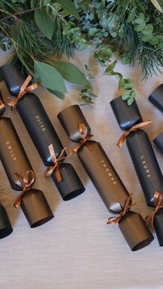 the chocolates are wrapped in black paper and tied with brown ribbon, along with greenery